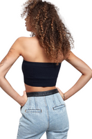 back of woman wearing a black cropped tube top with denim pants that have a black leather waistband 