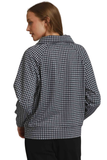 A woman shown from the back wearing a black and white gingham check long-sleeve jacket, paired with black pants, against a plain white background.