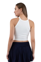 back of a white ribbed halter neckline tank top paired with a black pleated athletic skirt 