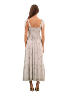 back of a floral maxi dress with tie straps, back of the dress has a smocked back and a flowy ruffle hemline. Dress is light green with a sage floral design 