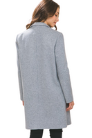 woman showing the back of a grey mid-length jacket