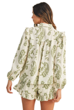 Back view of a cream and olive green floral matching set featuring a relaxed babydoll blouse with long puff sleeves and flowy ruffle hem shorts in lightweight textured gauze fabric.