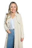 woman wearing a beige pleated trench coat. Coat is called has brown buttons down the front 