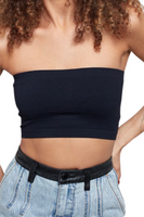 woman wearing a black cropped tube top with denim pants that have a black leather waistband and belt loops 