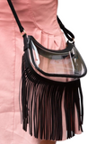 Person wearing a clear crossbody bag with black vegan leather trim and fringe at the bottom of the bag 