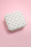 Blue bow print travel jewelry organizer case on pink background