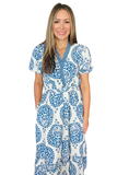 A woman modeling a short-sleeve V-neck maxi dress with a blue and white paisley pattern, set against a plain white background.