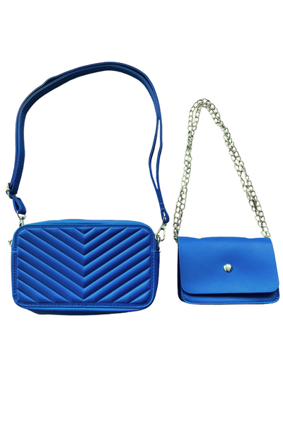 Blue rectangle purse with chevron quilted detailing and a matching blue adjustable strap. Smaller wallet size purse is next to the bigger purse with a silver chain strap that is also adjustable. Both bags are royal blue