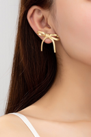 herringbone chain bow earrings on a woman's ear