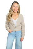 woman wearing a tan knit ribbed button down cardigan sweater over a white scoop neck top and light blue washed wide leg denim pants