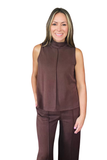 A woman modeling a sleeveless high-neck top and matching pants in a solid dark brown color, set against a plain white background.