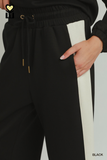 Close-up of black CloudKnit colorblock pants with ivory side stripe, drawstring waistband and side pocket