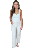 Woman wearing cream high rise cropped wide leg jeans with a white sleeveless top