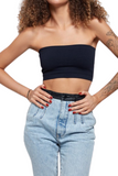 woman wearing a black cropped tube top with denim pants that have a black leather waistband and belt loops 