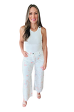 Front view of a woman wearing white cropped wide leg pants with a pastel floral cross stitch inspired print, relaxed fit, high rise waist, and lightweight stretch twill fabric styled with a white tank top.