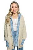 woman wearing a checkered denim jacket with a tan colored cardigan sweater 