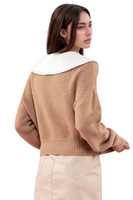 back of a tan cable knit sweater with a white doll collar detail 