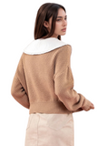 back of a tan cable knit sweater with a white doll collar detail 