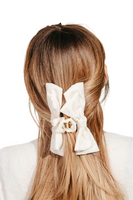 Ivory fabric bow hair claw in a light brown haired woman's hair 