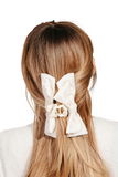 Ivory fabric bow hair claw in a light brown haired woman's hair 