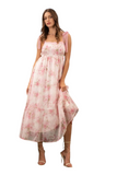 Woman wearing a white and pink floral maxi dress with a square neck line. Dress is an empire waist with crochet detailing along the top and straps. 