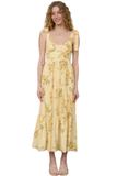 Model wearing a yellow floral tiered midi dress with scalloped lace tie straps and a flowy skirt