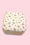 Pink floral travel jewelry organizer case on pink background