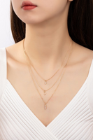 Layered gold delicate chain necklace with clear rhinestone charms on a woman's neck