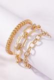 Gold chunky bracelet set. Set includes three gold bracelets. From left to right: popcorn style gold elastic bracelet, rectangle links with pave rhinestone links, gold oval link chain bracelet 