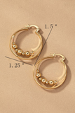Gold layered hoop earrings. Inner layer has gold bead detailing. Hoops have a latch closure. Loops are laying flat with measurements. 1.5 inches in length by 1.25 inches in width