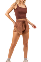 Mocha colored high-rise athletic shorts with mesh trim detail. Shorts have a front-tie