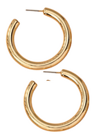 A pair of large gold hollow tube puffy hoop earrings with a polished finish, measuring 1.75 inches in diameter. The lightweight design features a bold, puffy silhouette and secure post-back closures, displayed on a white background.