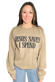 Tan crewneck sweatshirt with “Jesus Saves I Spend” printed in bold black lettering on the front, styled with a relaxed light washed denim jeans