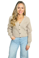 woman wearing a tan v-neck style button down ribbed knit cardigan tucked into light wash wide leg denim pants 