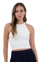 woman wearing a ribbed white round neck halter neckline tank top. Tank top is slightly cropped and paired with a black pleated skirt 