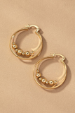 gold layered hoop earrings with circular gold beads on the inner hoop. Hoops have latch closures.