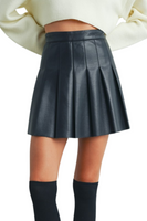 Black pleated faux leather mini skirt with a high waist and side zipper closure, styled with a cropped cream sweater and knee-high socks.
