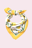 Lemon pattern bandana scarf with green trim styled in a knotted headscarf look