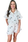 Front view of a white mallard duck print matching set with a collared button down blouse, ruffle sleeve detail, elastic drawstring waist shorts, side pockets, and ruffle trim shorts.