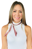 A smiling woman with blonde-highlighted hair wearing a white ribbed halter top and a cream bandana-style neck scarf with a burgundy border, set against a plain white background.