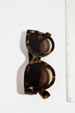 Photo of tortoise shell cat eye sunglasses next to a ruler. Sunglasses are measuring about 6.5 inches in length