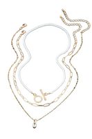 A set of three necklaces featuring a pearl chain choker with a toggle closure, a fine paperclip chain, and a delicate twisted chain with a CZ pendant on a white background