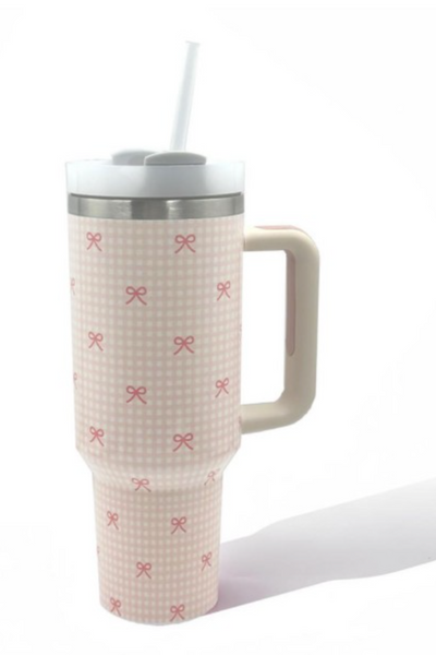 40 oz stainless steel tumbler cup, cup is wrapped in a light pink plaid pattern with pink bows, cup has a handle and a white twist on top. 