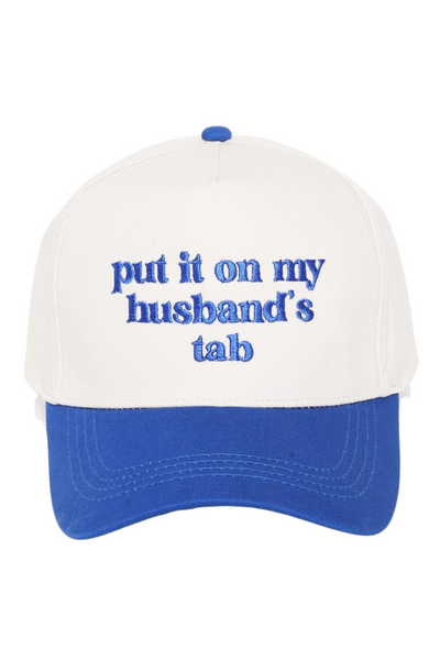 White baseball hat with a royal blue bill, hat has "put it on my husband's tab" embroidered in royal blue 