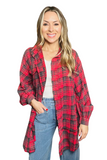 Woman wearing an oversized red and green flannel shirt with light wash denim pants 