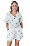 Front view of a white mallard duck print matching set featuring a button down short sleeve blouse with ruffle sleeve detail, elastic drawstring waist shorts, side pockets, and ruffle hem shorts with a relaxed fit.