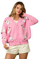 Woman wearing a pink button down cardigan with sequin Santa detailing on the front of the cardigan 