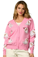 Woman wearing a pink button down cardigan with sequin Santa detailing on the front of the cardigan 