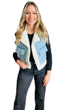 woman wearing a black long sleeve shirt and dark gray pants with a white sherpa lined denim vest. The vest has 2 cargo pockets with a flap and button closure. 