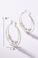 Silver layered hoop earrings. Inner layer has silver bead detailing. Hoops have a latch closure. Loops are laying flat with measurements. 1.5 inches in length by 1.25 inches in width